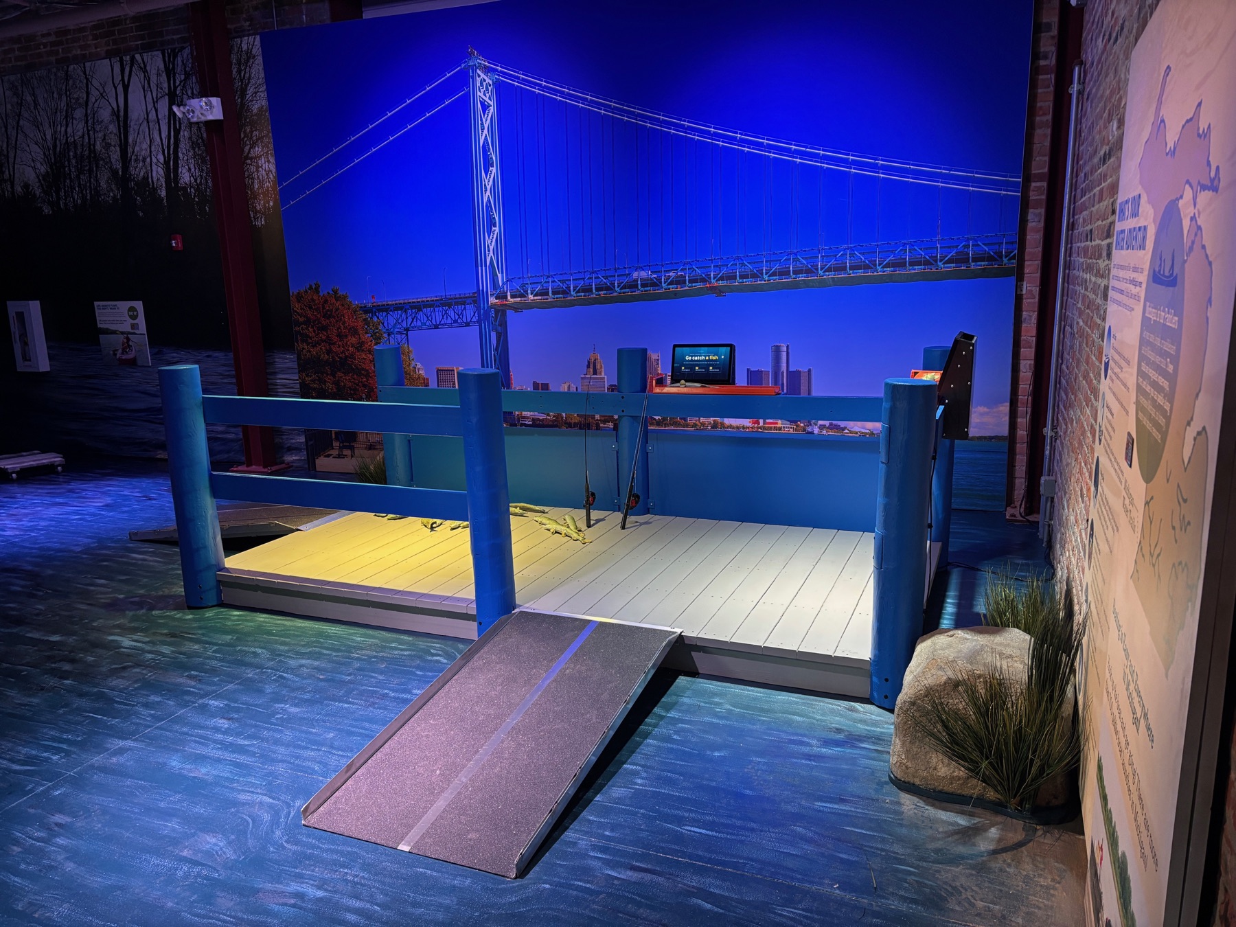 Fishing exhibit dock in front of a Detroit river and bridge mural