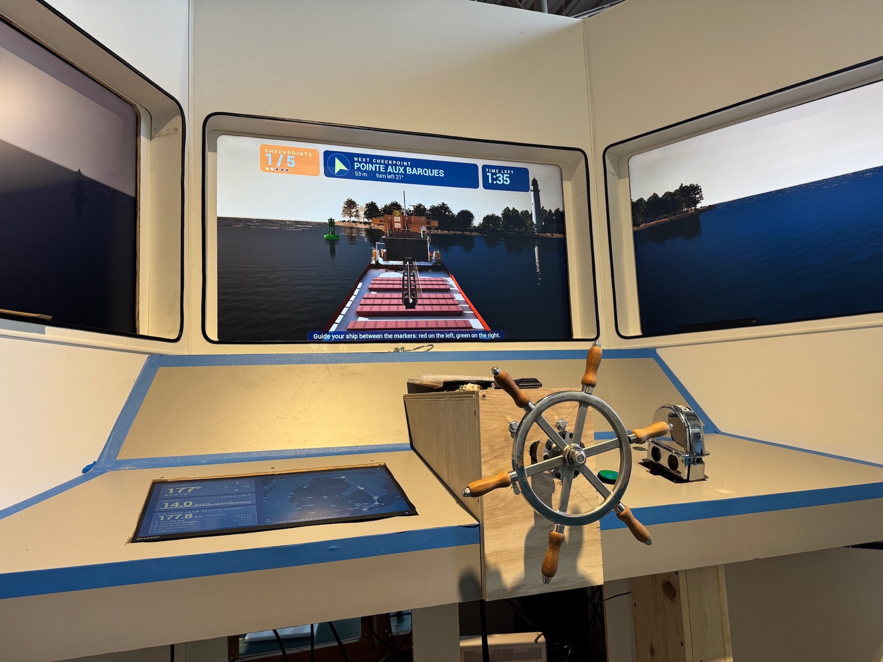 Bridge screens showing a lighthouse on the water ahead, with the wheel and throttle in front